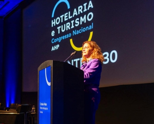 Taxa Turística no Funchal: Cristina Pedra diz que a medida vai “aumentar” a “qualidade” das infraestruturas e serviços municipais Na abertura do 34º Congresso Nacional de Hotelaria e Turismo, que decorre até sexta-feira, no Centro de Congressos da Madeira, a presidente da Câmara Municipal do Funchal, Cristina Pedra, esclareceu que a aplicação da Taxa Turística pelo Município do Funchal, em 2024, tem por objetivo “mitigar” os efeitos sociais e/ou ambientais, causados pelas atividades turísticas na atividade do concelho, garantindo que a mesma deve ser aplicada com” proporcionalidade” e “equilíbrio”. Cristina Pedra sublinha que a “Taxa” não é um imposto, pelo que, existirá uma relação “sinalagmática” entre o valor arrecadado e o fim a que se destina. A autarca acredita que a existência desta medida, a ser repercutida nas infraestruturas públicas municipais e nos serviços prestados pelo município, será um meio do Município do Funchal aumentar a qualidade das infraestruturas e serviços municipais à própria comunidade turística. “Não é justo nem razoável pedir aos munícipes que suportem a totalidade destes custos, pois não são eles exclusivos beneficiários”, realçou. A presidente da CMF lembrou que por todo o mundo, o critério utilizado para cobrança desta taxa são as dormidas. Nesse sentido, é lógico que seja o Funchal a arrecadar a maior fatia da receita, dado que é na capital da Região Autónoma da Madeira que se encontra a maioria dos estabelecimentos hoteleiros. É também no Funchal que existe a maior pressão sobre todas as infraestruturas públicas, desde a rede de água potável ao saneamento básico, das estradas aos equipamentos culturais e de lazer, e é também no Funchal que se encontra a maioria de equipamentos regionais ligados à cultura e a cidade que mais investe em atividades culturais, sendo que o investimento representa já 6 milhões de euros do Orçamento Municipal para 2024. É neste contexto que considera “justo que o turista contribua para compensar os impactos, contribuição essa que não deve prejudicar a competitividade do Turismo”. A autarca recordou que a Lei 73/2013 é clara quando consagra que compete às autoridades locais a afetação, a definição e aplicação da taxa turística. Contudo, considera fundamental existir cooperação entre os privados e o sector publico. Nesse sentido, revelou que o executivo municipal tem vindo a promover reuniões com as entidades privadas e públicas, lembrando que ainda ontem efetuou uma auscultação ao tecido empresarial, através da ACIF, sobre a forma de aplicar a Taxa Turística. “Não menos importante”, frisou Cristina Pedra, “é a fase de consulta pública que a CMF irá promover, o que proporcionará ao cidadão e a qualquer entidade, a possibilidade de contribuir com reflexões e sugestões que serão devidamente ponderadas”. Cristina Pedra finalizou o discurso lançando um desafio face à “preocupação que algumas figuras com responsabilidade turística nacional evidenciaram com a aplicação desta taxa na Madeira, atitude que, embora sendo legítima, não tiveram relativamente a Lisboa, Porto ou outras cidades do país. Desafio, pois, os defensores dessa medida a pedirem ao Governo da República a criação de uma taxa nacional e a dizerem aos municípios, nomeadamente Lisboa e Porto, que vão abdicar das suas receitas em favor do Orçamento de Estado”.